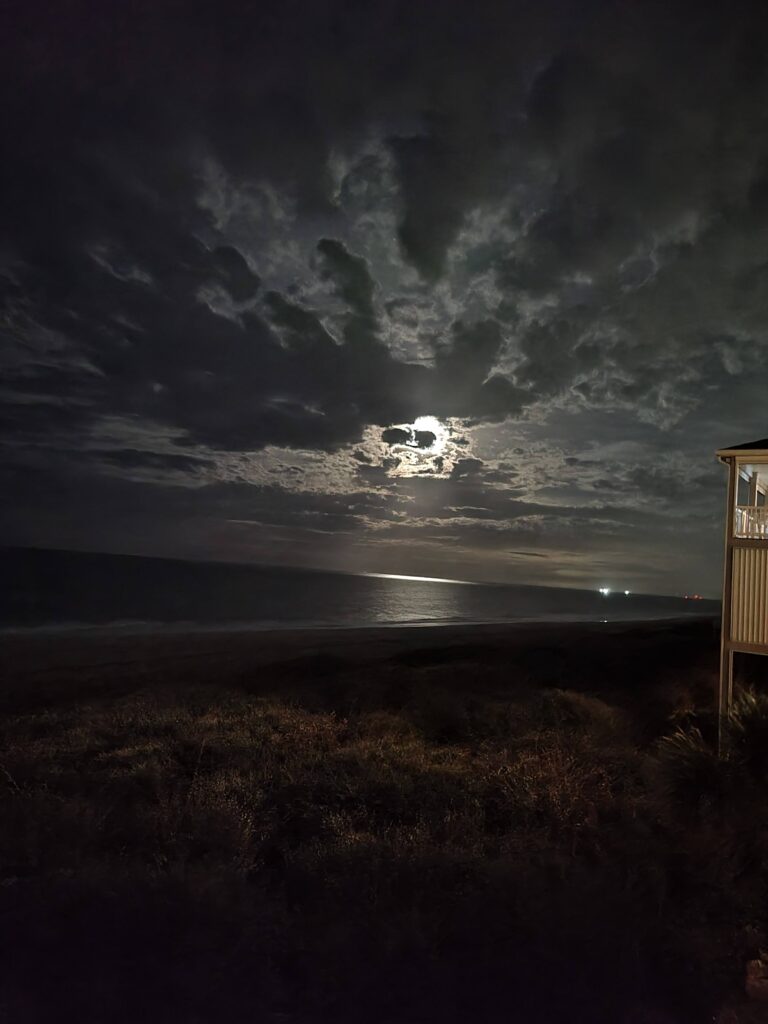 Dark night shot of Indian Beach with the moon poking out of the clouds.