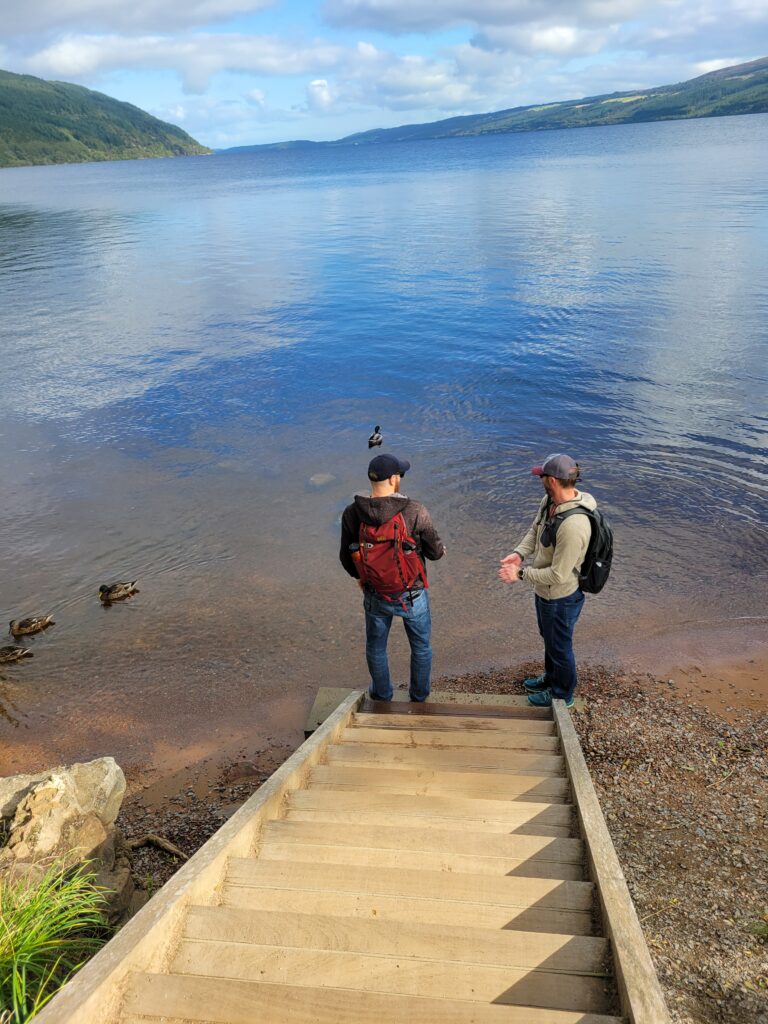 Two men standing at the dock at Loch Ness.